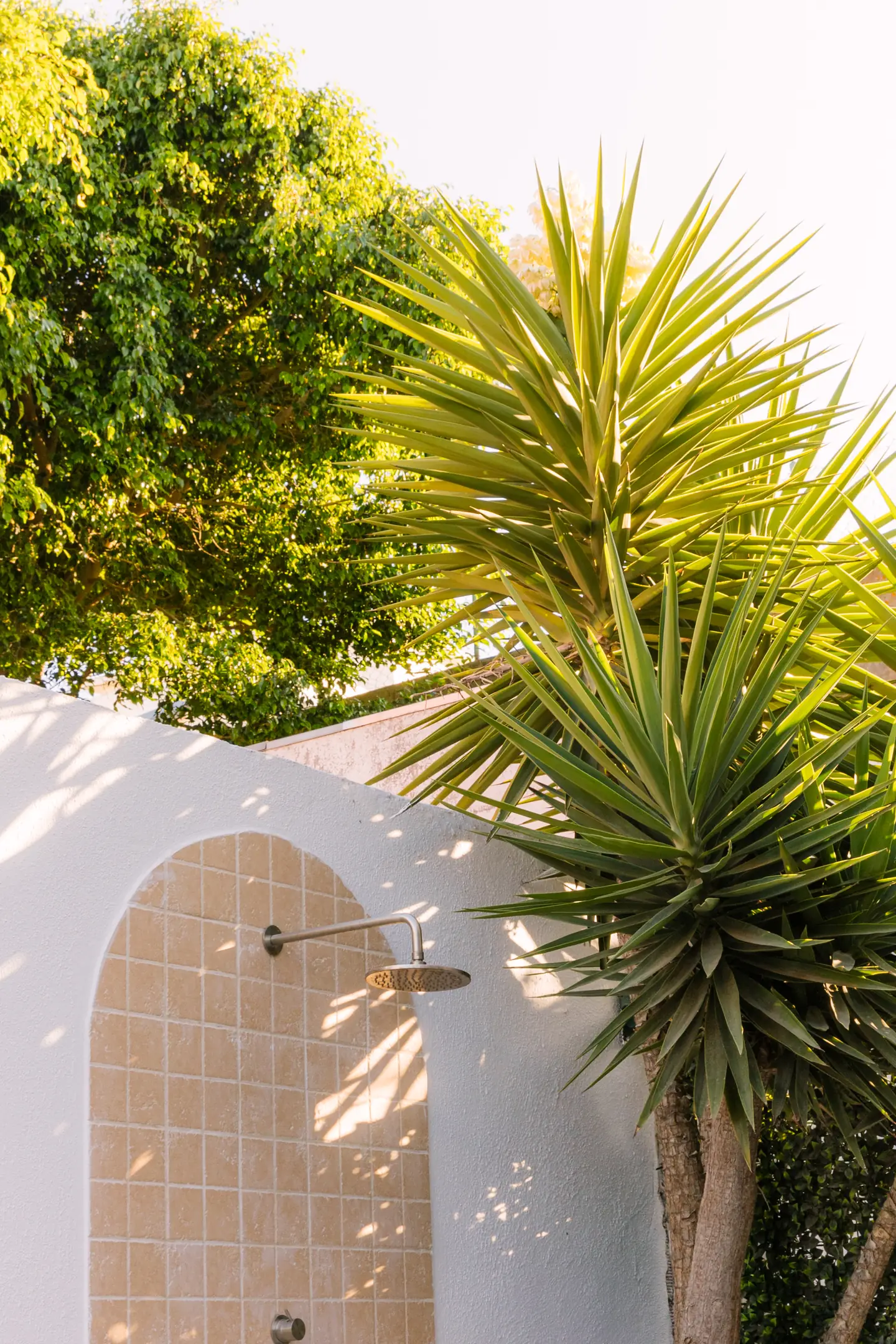 Arched garden shower surrounded by greenery