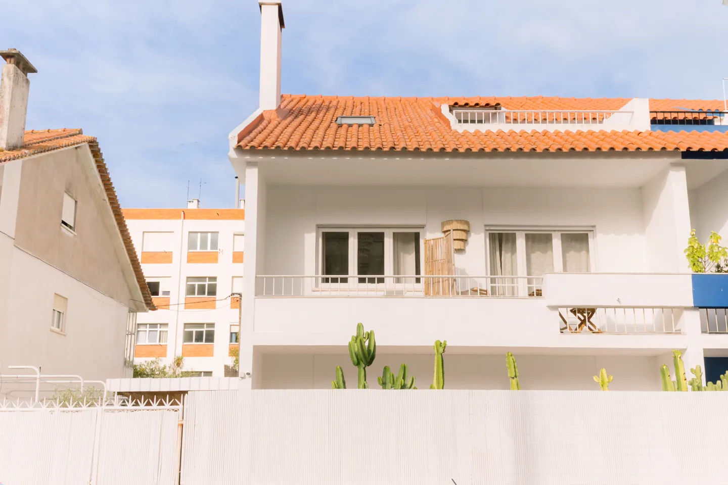 Front facade of Casa Caparica with orange roof tiles and cacti