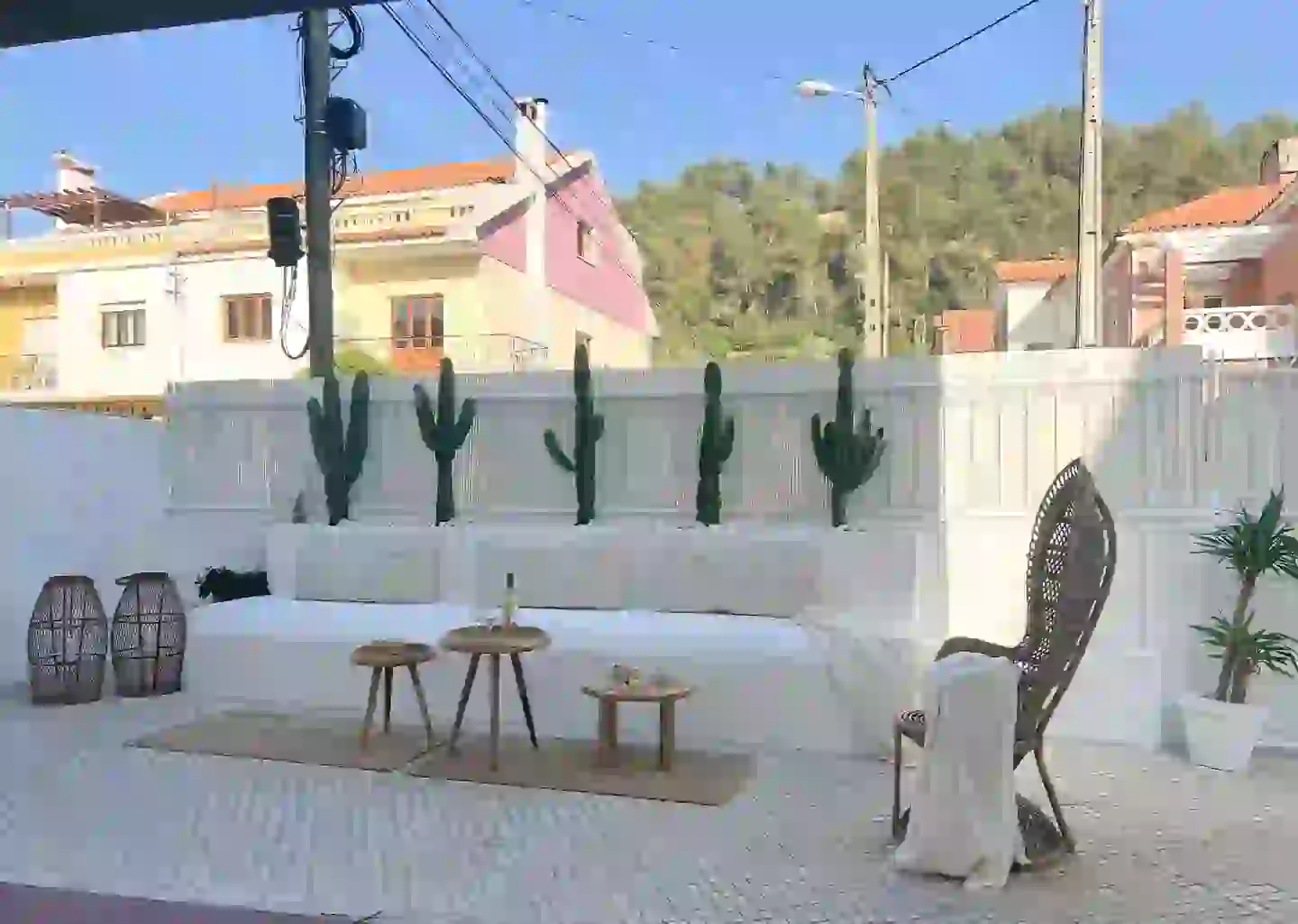 Outdoor terrace of Casa Caparica with white sofa, cacti and wicker chair